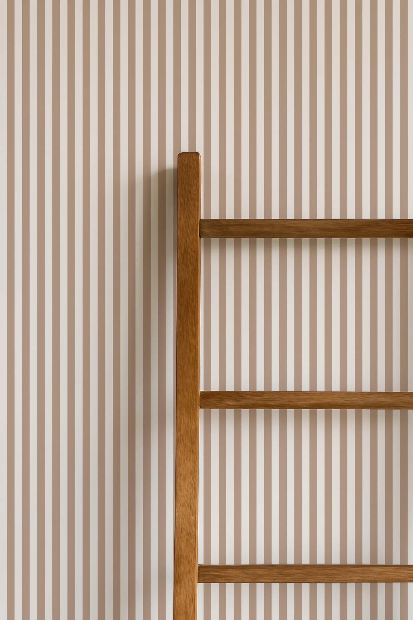 a wooden ladder leaning against a wall with horizontal stripes.