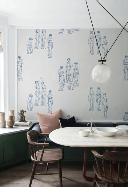 a dining room with a white table and chairs, a patterned wallpaper with blue and white human figures, and a hanging light fixture.