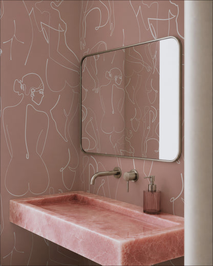 a bathroom with a pink marble sink, a mirror, and a pink soap dispenser. The bathroom has a pink and white color scheme, with a pink marble sink and a pink wall with a white pattern.