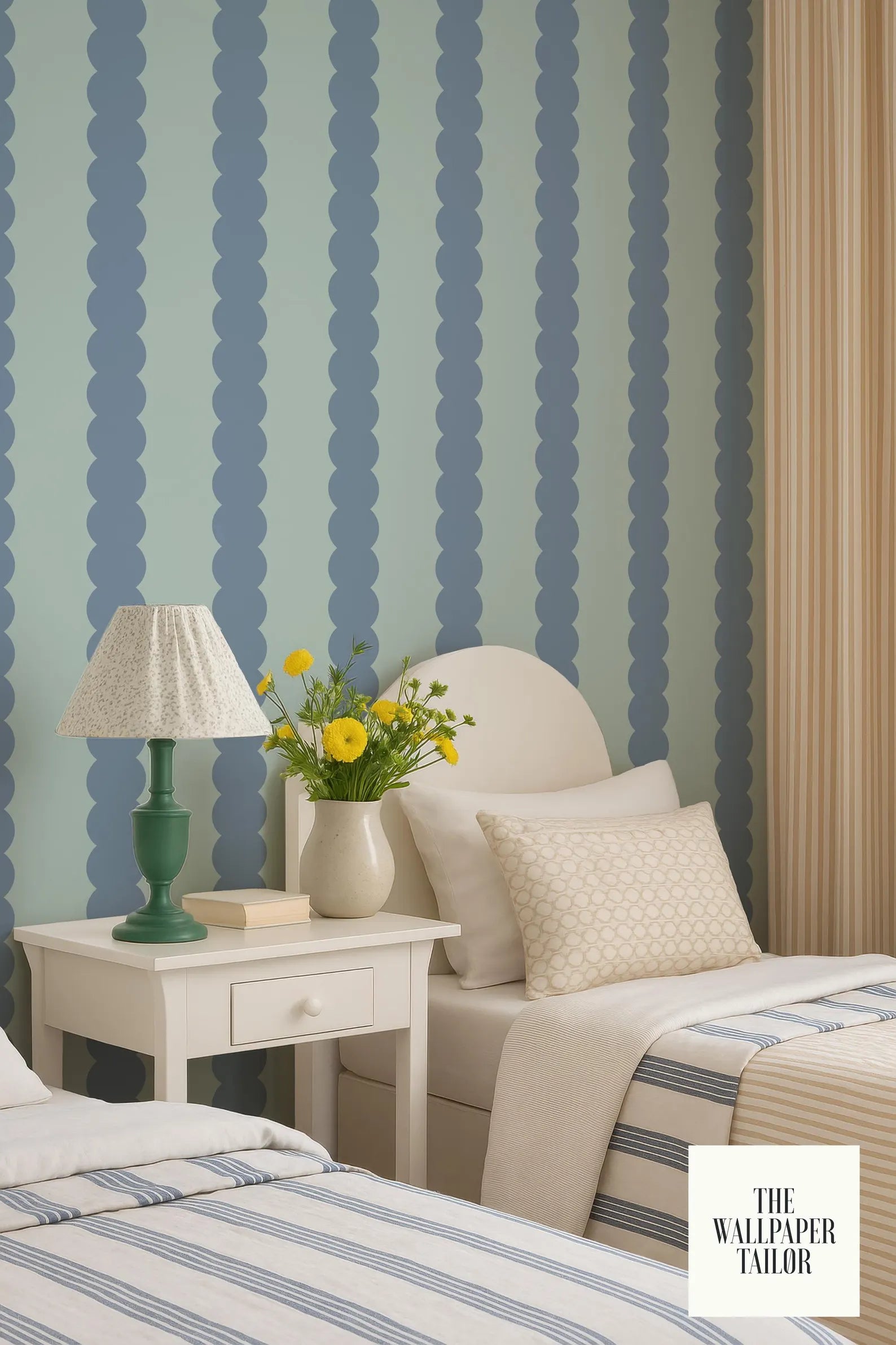 a cozy bedroom with a blue and white striped wallpaper, a white bed with a single pillow, and a nightstand with a lamp and a vase of yellow flowers.