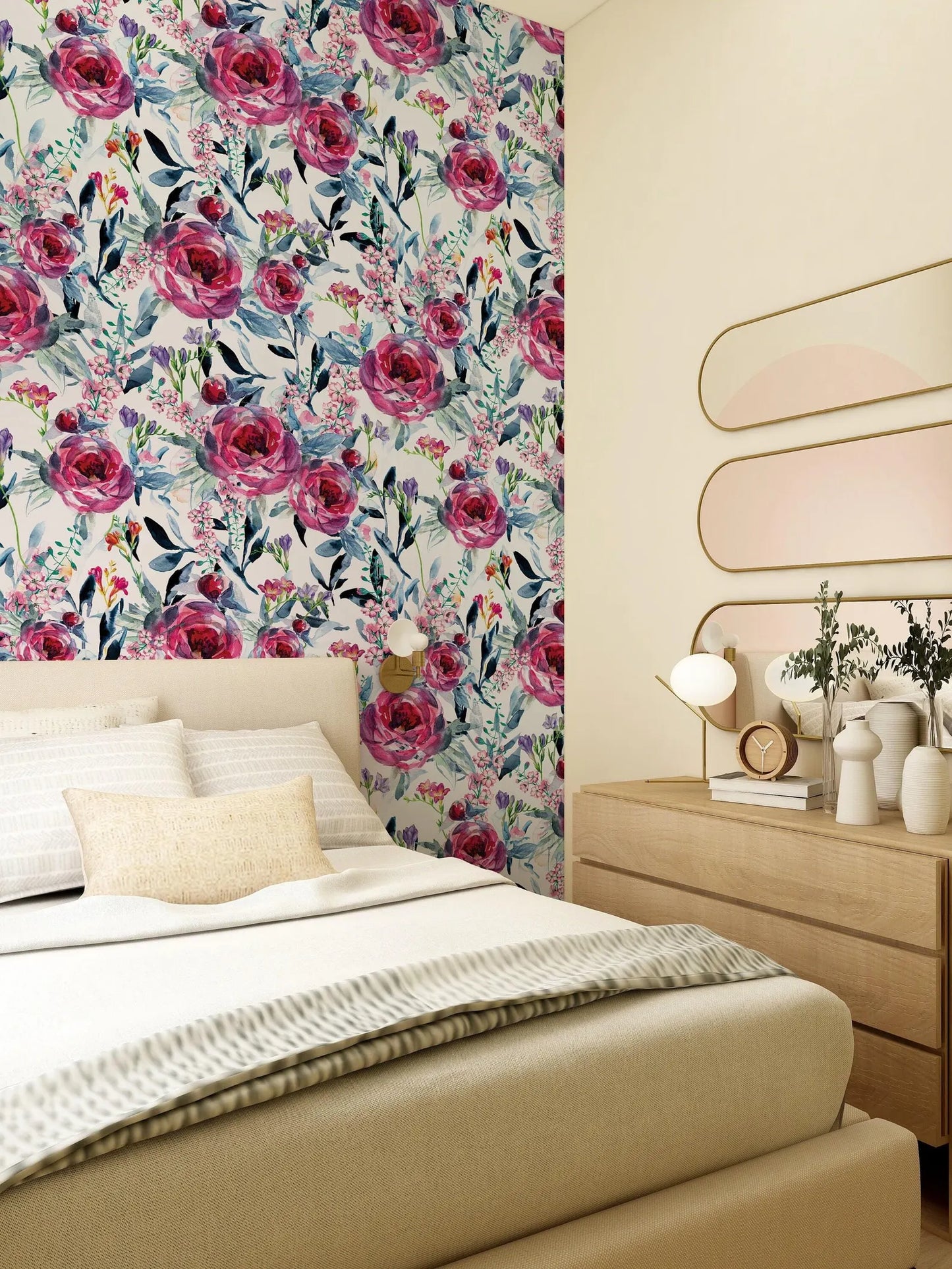 a bedroom with a floral wallpaper on the wall behind the bed. The room has a wooden dresser and a mirror above it. The bed has white linens and a single throw blanket.