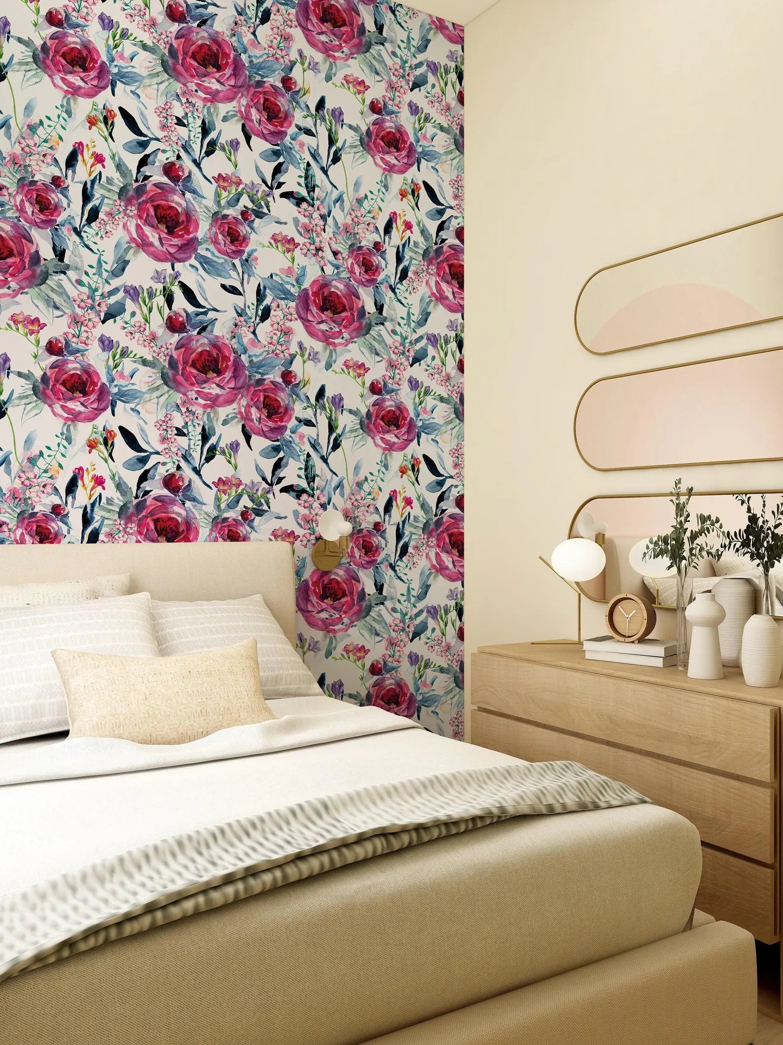 a bedroom with a floral wallpaper on the wall behind the bed. The room has a wooden dresser and a mirror above it. The bed has white linens and a single throw blanket.