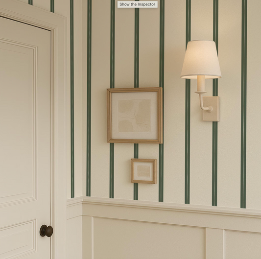 a corner of a room with a framed picture on the wall, a wall lamp, and a door.