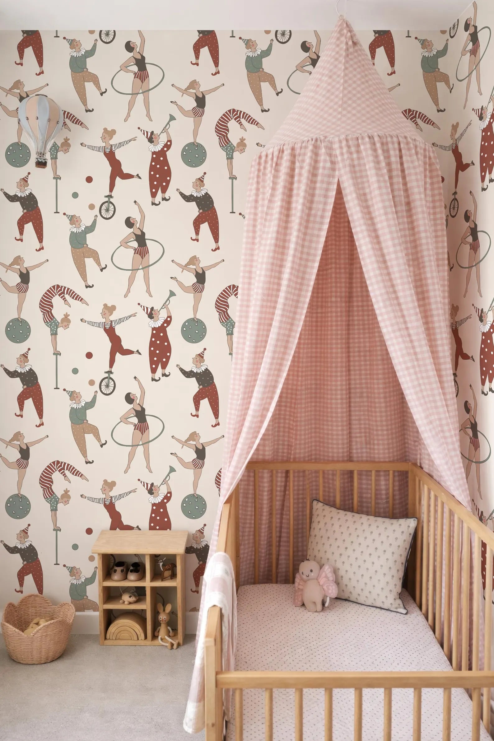 a nursery room with a wooden crib, a canopy bed, and a colorful circus-themed wallpaper.