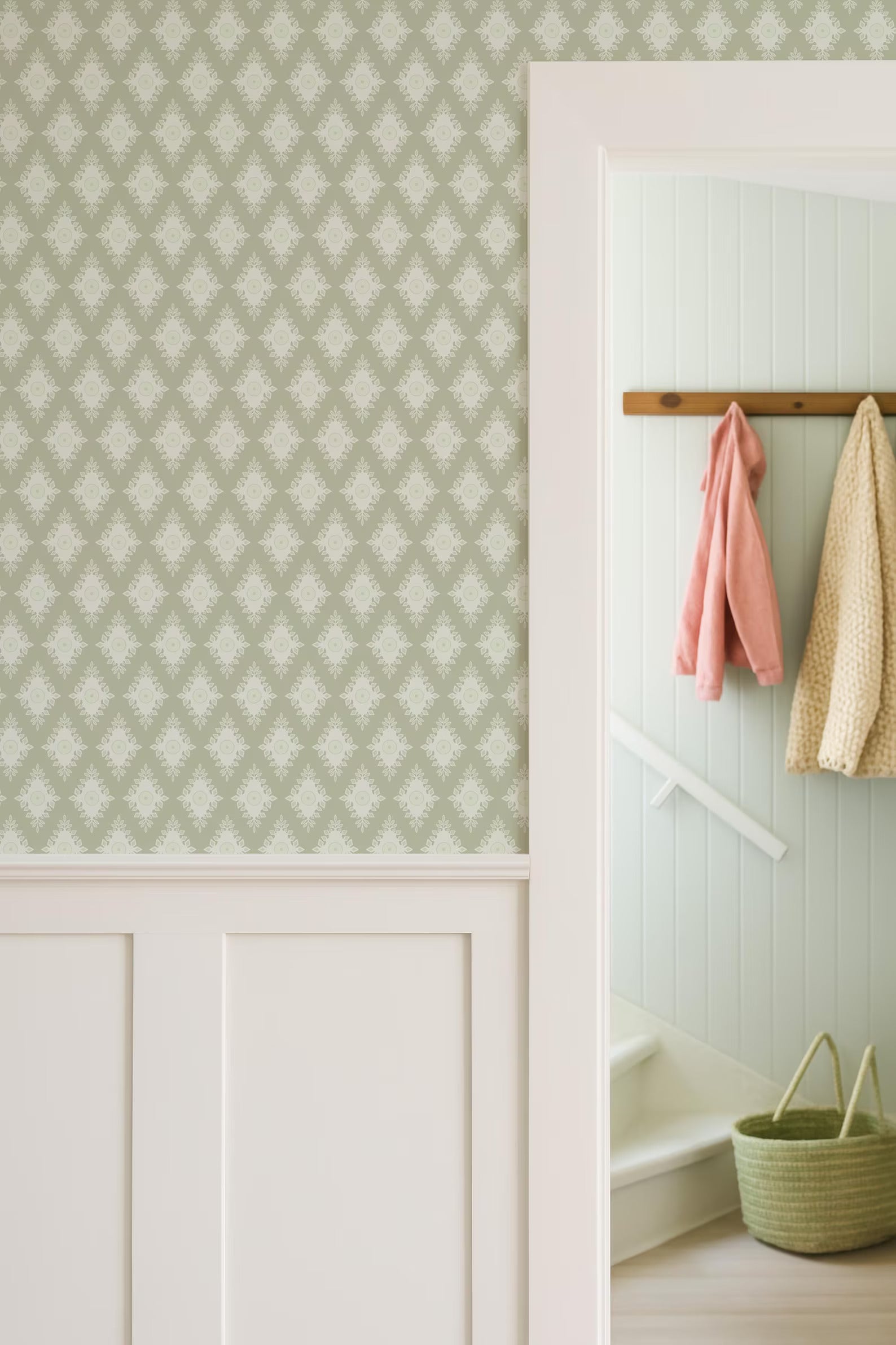 a hallway with a patterned wallpaper, a white door frame, and a coat rack with hanging clothes.