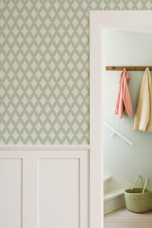 a hallway with a patterned wallpaper, a white door frame, and a coat rack with hanging clothes.