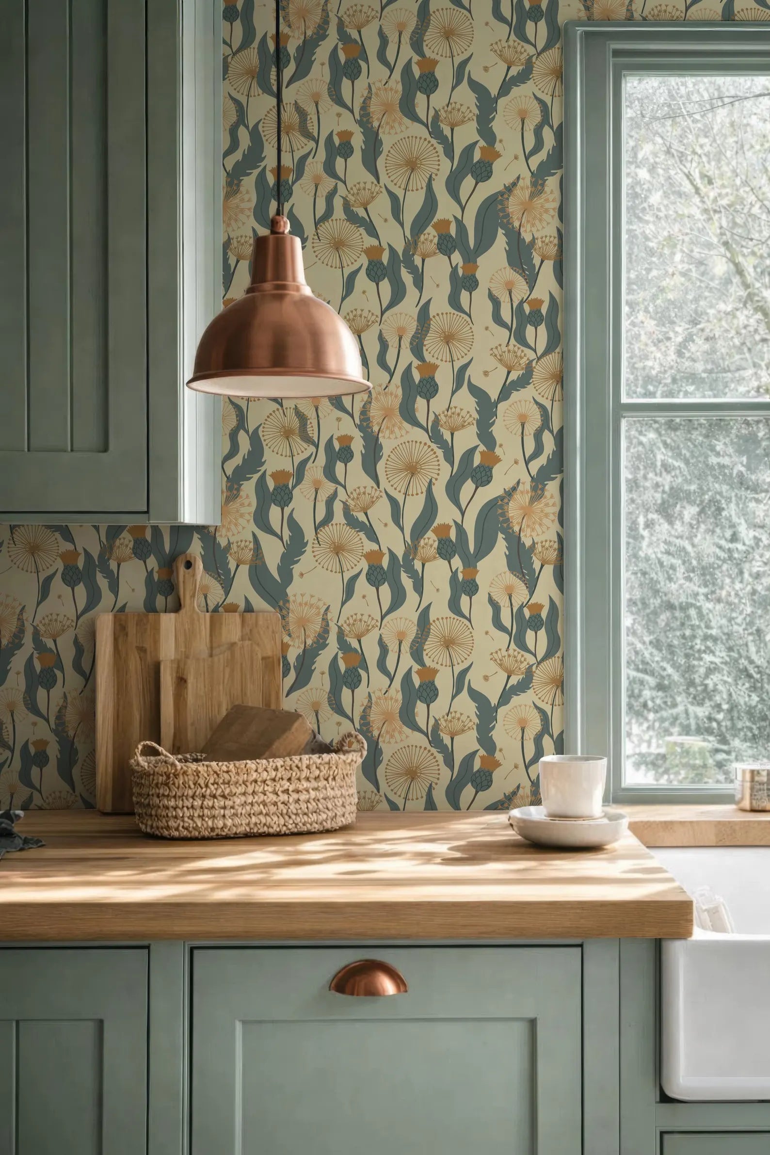 a kitchen with a wooden countertop, a woven basket, a copper pendant light, and a window with a view of trees outside.