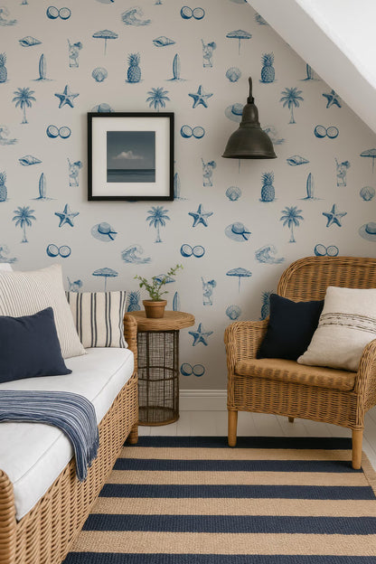 a cozy and inviting living space with a wicker chair, a striped rug, and a framed picture on the wall. The room has a beach-themed decor, with a patterned wallpaper featuring palm trees, starfish, and other nautical elements. The chair is positioned near a small table, which has a plant on it, adding a touch of greenery to the space. The overall atmosphere of the room is warm and welcoming, with a harmonious blend of colors and textures.
