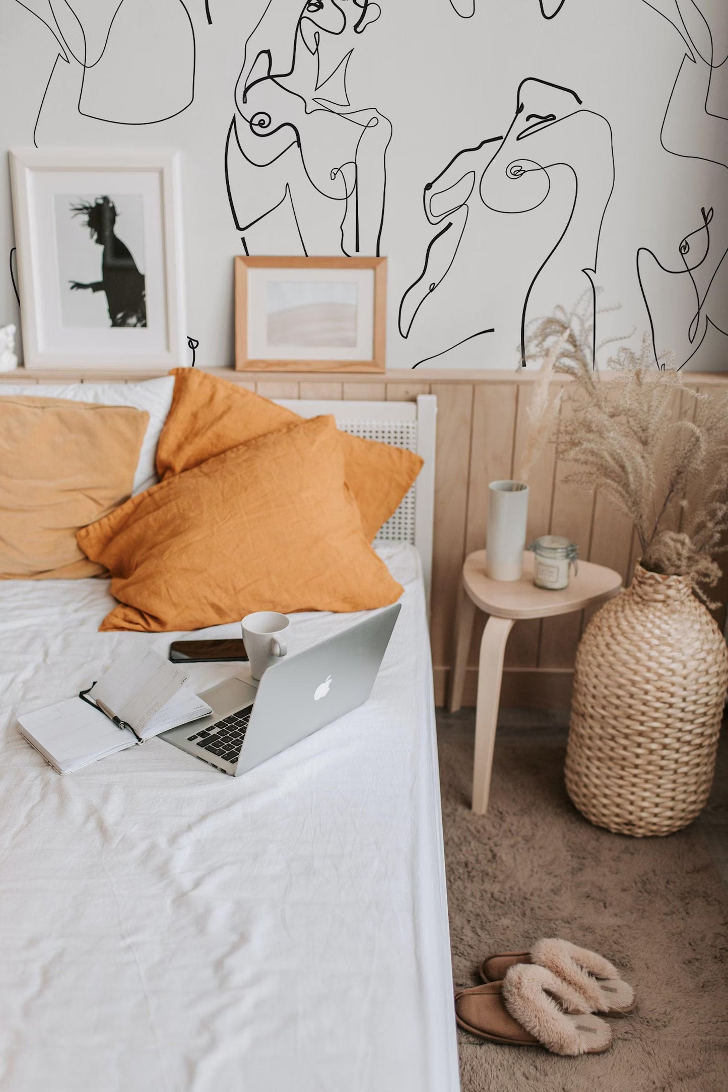 a cozy bedroom scene with a bed, a laptop, and various decorative elements.