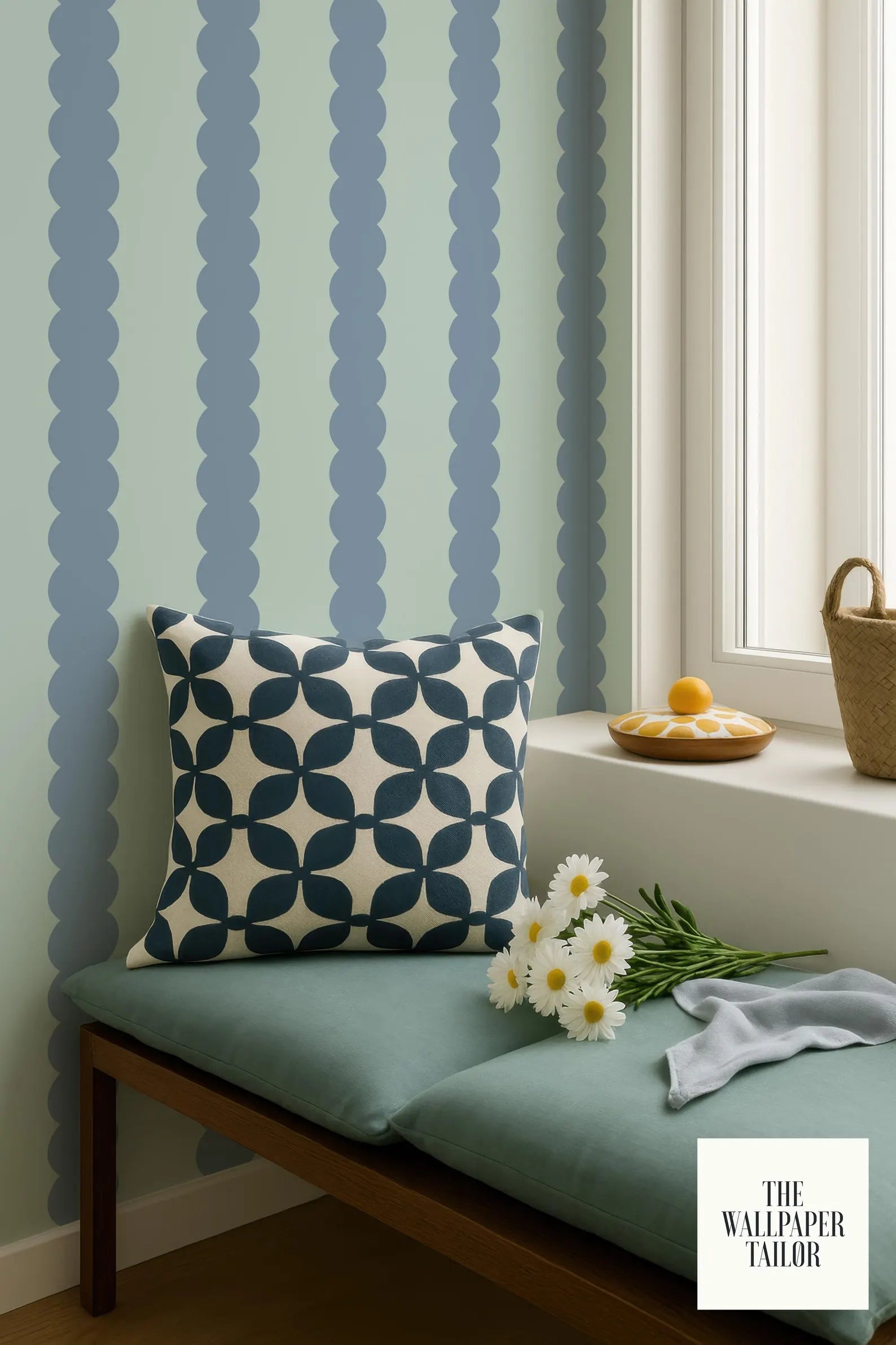 a cozy corner with a blue and white patterned pillow, a bouquet of white daisies, and a basket of fruit on a windowsill. The backdrop is a wall with vertical blue and white stripes.