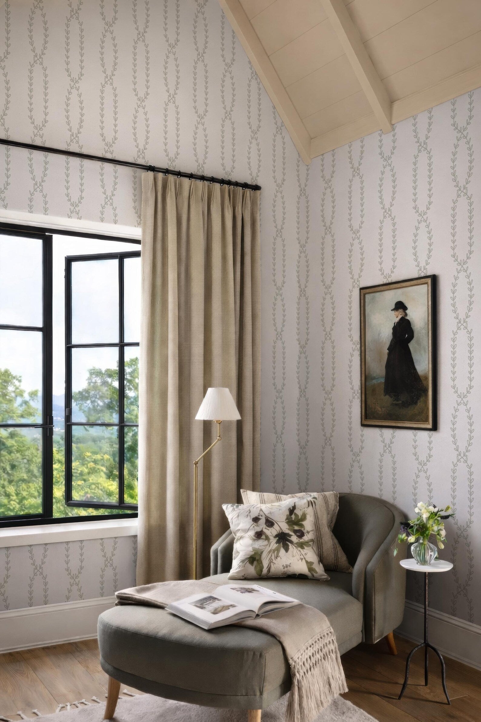 a cozy and inviting living room with a large window overlooking a scenic outdoor view. The room is adorned with a painting of a woman in a black dress, a lamp, and a comfortable armchair with a throw blanket. The overall decor and arrangement create a warm and welcoming atmosphere.