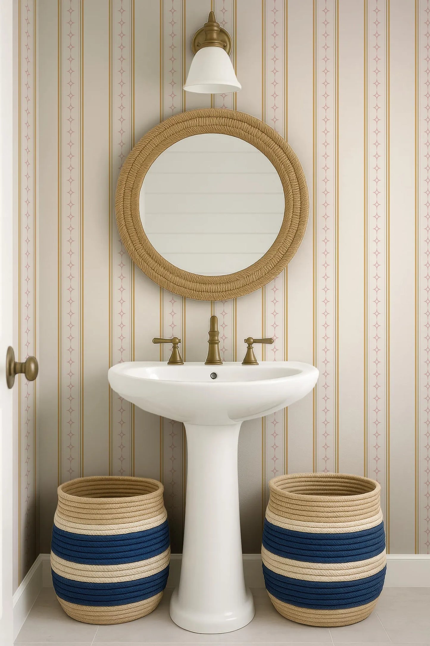 a bathroom with a white pedestal sink, a round mirror, and two woven baskets placed on either side of the sink.