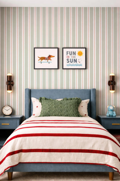 a bedroom with a blue headboard and a striped comforter. Above the bed, there are two framed pictures on the wall, one depicting a dog and the other with the text "Fun in the Sun". The room also has a clock on the wall and a stuffed animal on a nightstand.