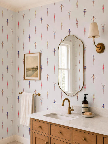 a bathroom with a white sink, a mirror, and a wallpapered wall with a pattern of swimming figures. There is also a wooden vanity with a sink and a bottle of soap on it.