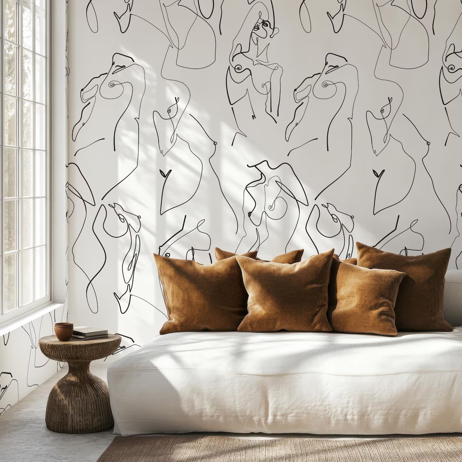 a modern and minimalist living space with a white sofa and brown throw pillows. The sofa is positioned against a wall with a repeating abstract line drawing design, creating a visually striking and artistic backdrop. The room is well-lit, with natural light coming in from a window, enhancing the overall ambiance of the space.