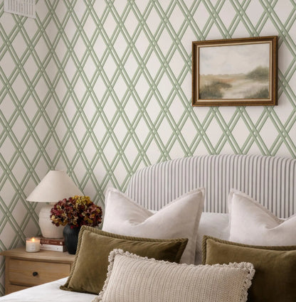 a bedroom with a striped headboard, a framed landscape painting on the wall, and a wooden nightstand with a lamp and a vase of flowers.