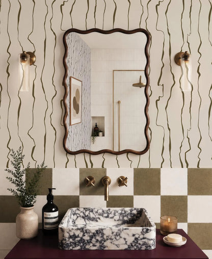 a bathroom with a marble-patterned sink, a large mirror, and a checkered tile backsplash. The bathroom also includes a potted plant, a soap dispenser, and a candle on the counter.