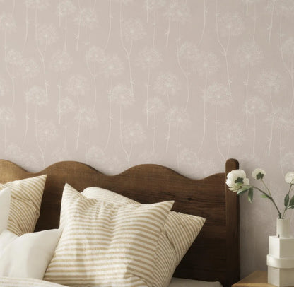 a bedroom with a wooden headboard and a bed with striped pillows. The wall behind the bed has a patterned wallpaper with white flowers. There is a vase with white flowers on the bedside table.