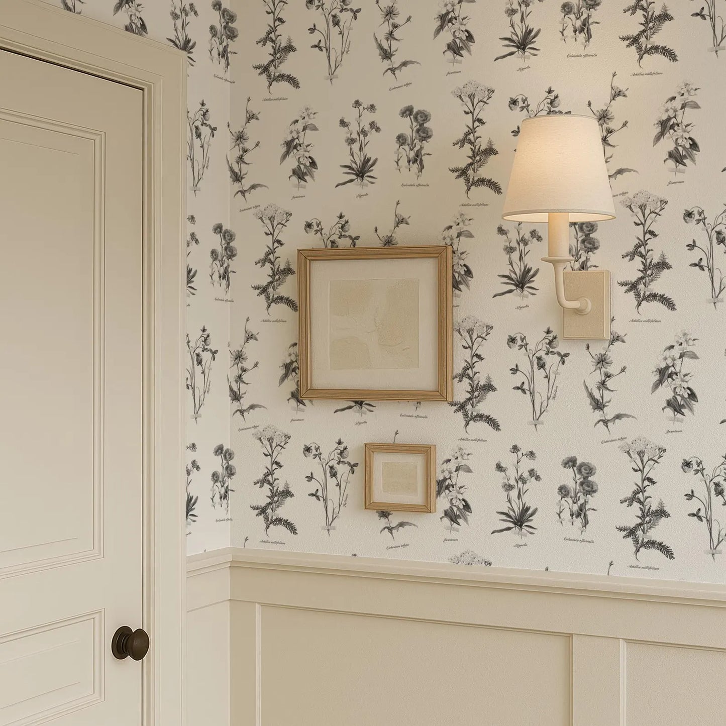 a wallpapered wall with a framed picture and a wall sconce, creating a cozy and inviting atmosphere.