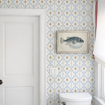 a bathroom with a white door, a framed picture of a fish on the wall, and a white toilet.