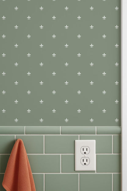 a wall with a green tile pattern and a white electrical outlet on the wall. There is also a red towel hanging on the wall.
