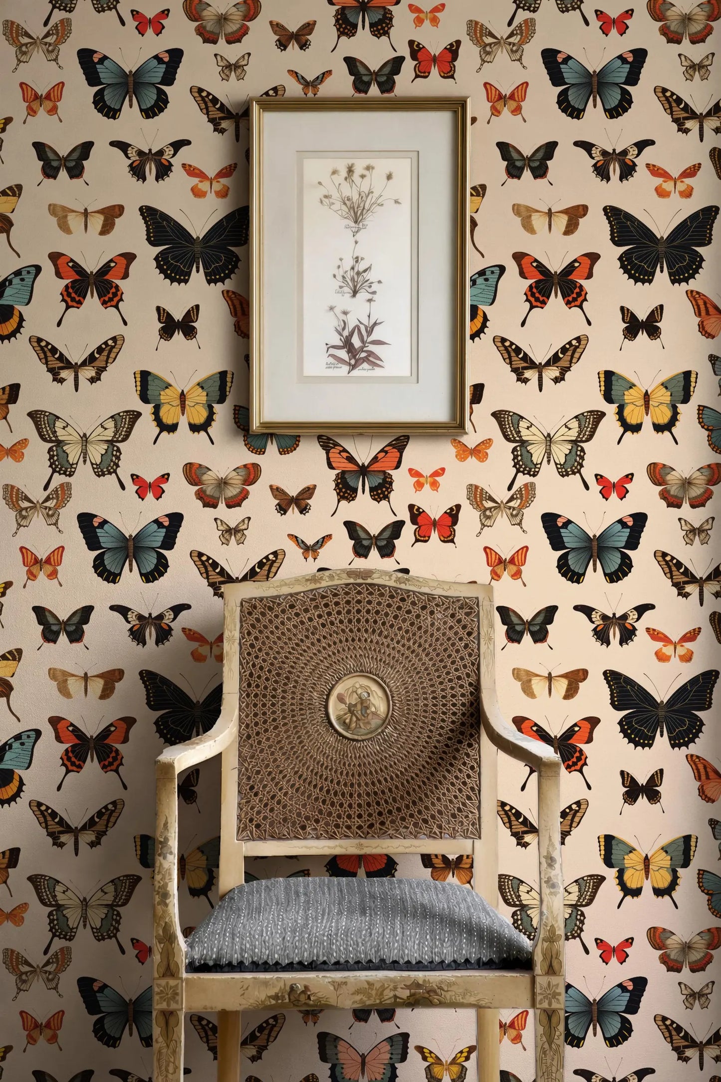 a chair with a woven seat and backrest, set against a wall adorned with a repeating pattern of colorful butterflies. Above the chair, there is a framed picture hanging on the wall.