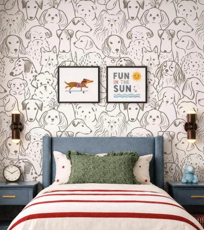 a bedroom with a bed, two nightstands, and a wallpapered wall with a repeating pattern of dog faces. Above the bed, there are two framed pictures of dogs. The wall also has a playful message that reads "Fun in the Sun".