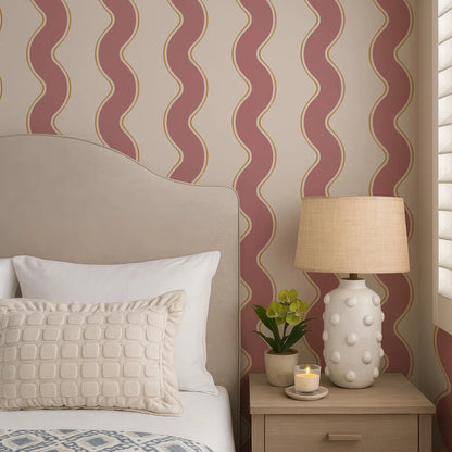 a cozy bedroom scene with a bed, a lamp, and a decorative pillow. The bed has a gray headboard and white pillows, and the lamp has a beige lampshade with white polka dots. The wall behind the bed has a pattern of red and white stripes.
