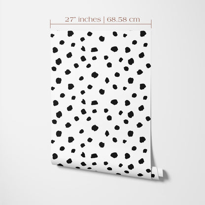 a white wall with a pattern of black dots or spots, creating a visually striking design.