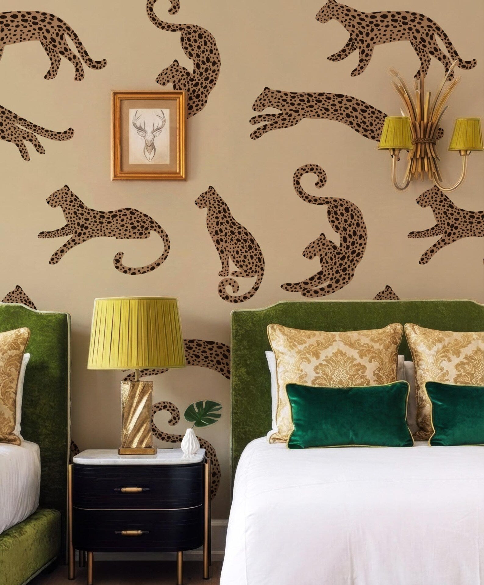a bedroom with a large wall mural of leopards, a green headboard, and a white bed with green and gold pillows. There is a black nightstand with a lamp and a picture frame on it.