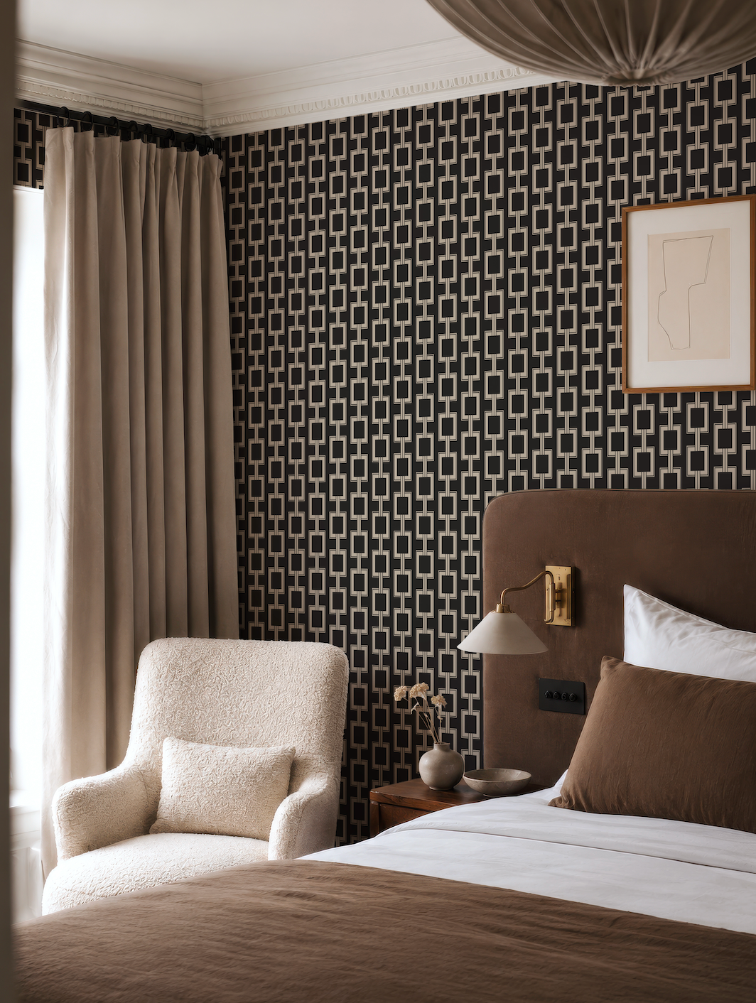 a cozy and stylish bedroom with a large bed, a plush white armchair, and a patterned wallpaper.