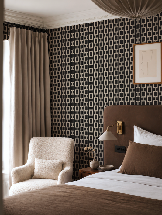 a cozy and stylish bedroom with a large bed, a plush white armchair, and a patterned wallpaper.