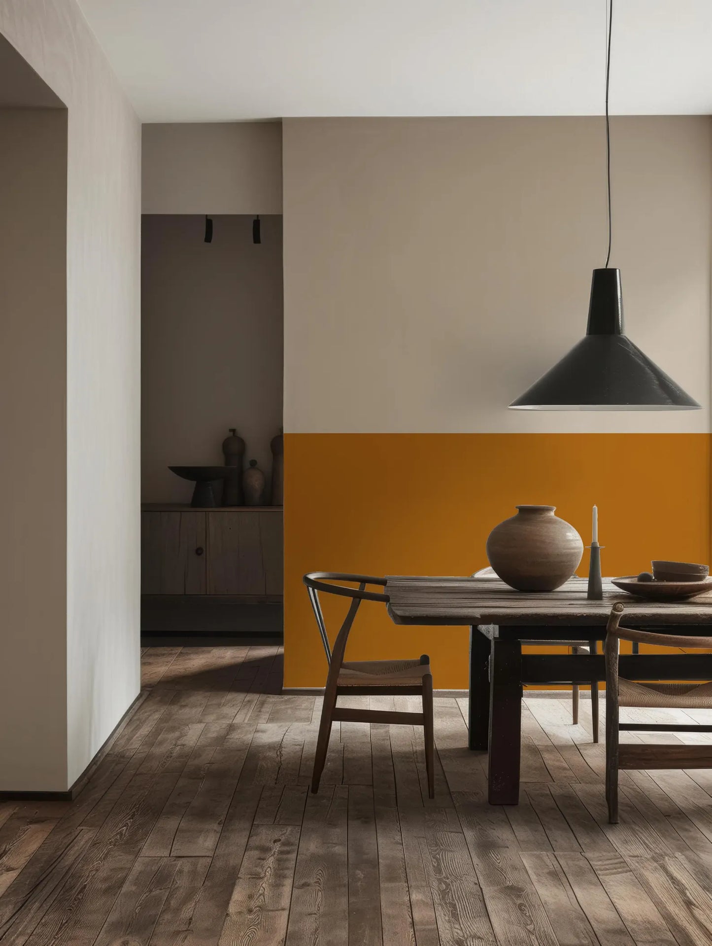 a modern dining room with a wooden table and chairs, a hanging pendant light, and a wooden floor.