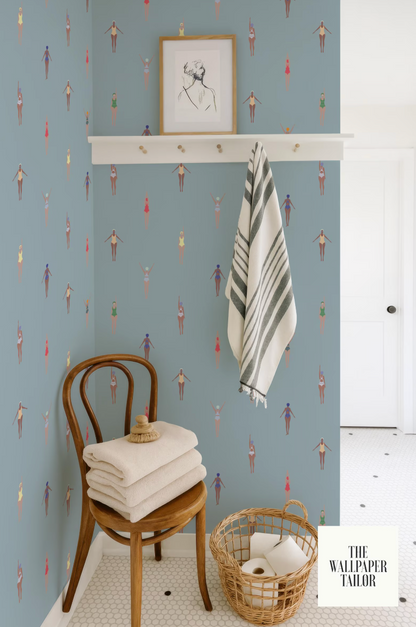 a bathroom with a blue and white color scheme, a wooden chair with folded towels, a towel rack with a striped towel, and a basket of toilet paper.