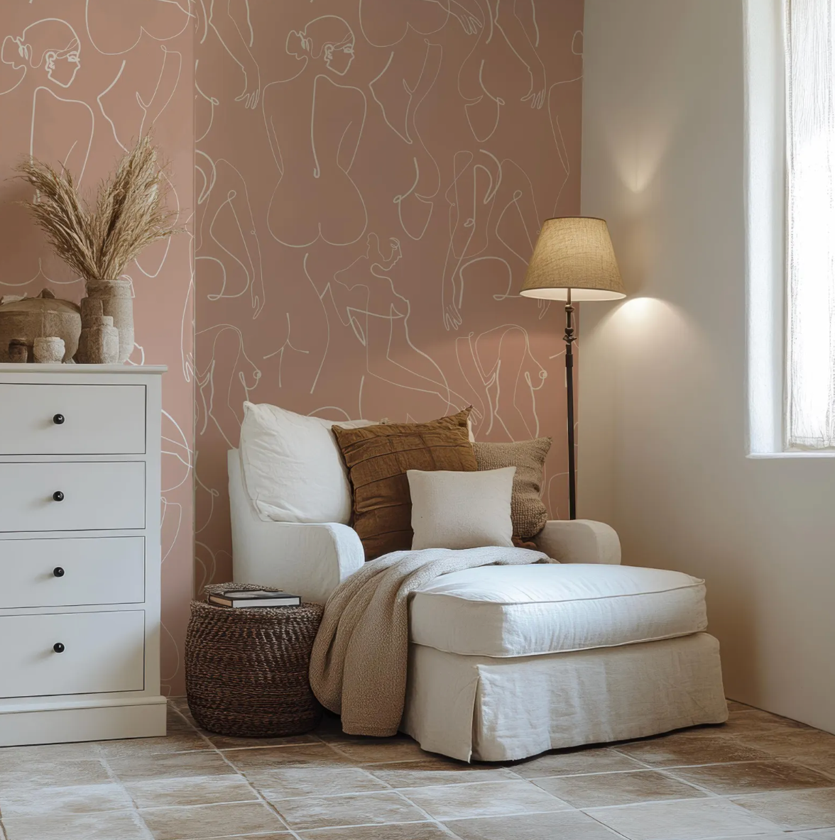 a cozy and inviting living space with a comfortable chair, a white ottoman, and a lamp providing warm lighting. The room has a pink wall with abstract line drawings, adding a touch of artistic flair to the space.