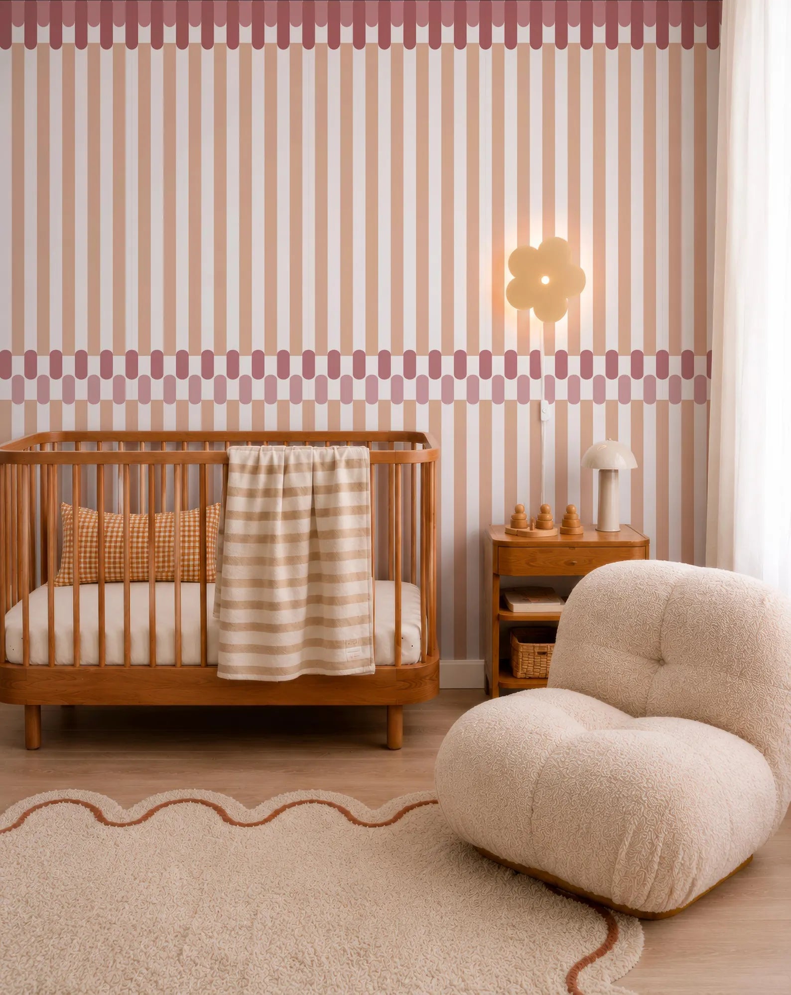 a cozy nursery room with a wooden crib, a plush chair, and a striped wall with a flower-shaped light fixture.
