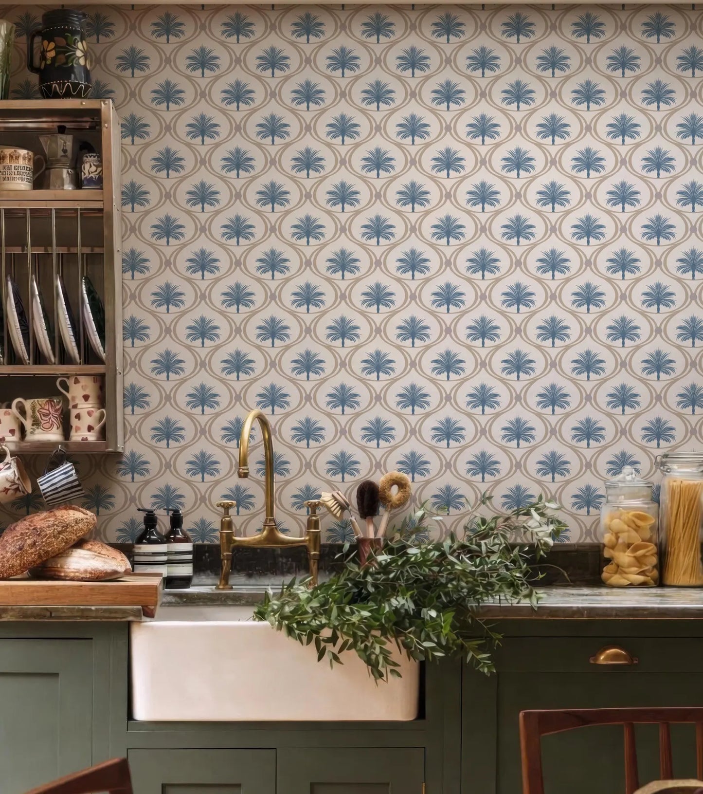 a kitchen with a sink, a wooden shelf with dishes, and a wall with a patterned wallpaper. The kitchen has a rustic and cozy atmosphere, with a mix of natural and vintage elements.