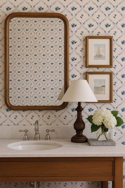 a bathroom sink with a mirror above it, a lamp on the counter, and a framed picture of a sailboat on the wall.
