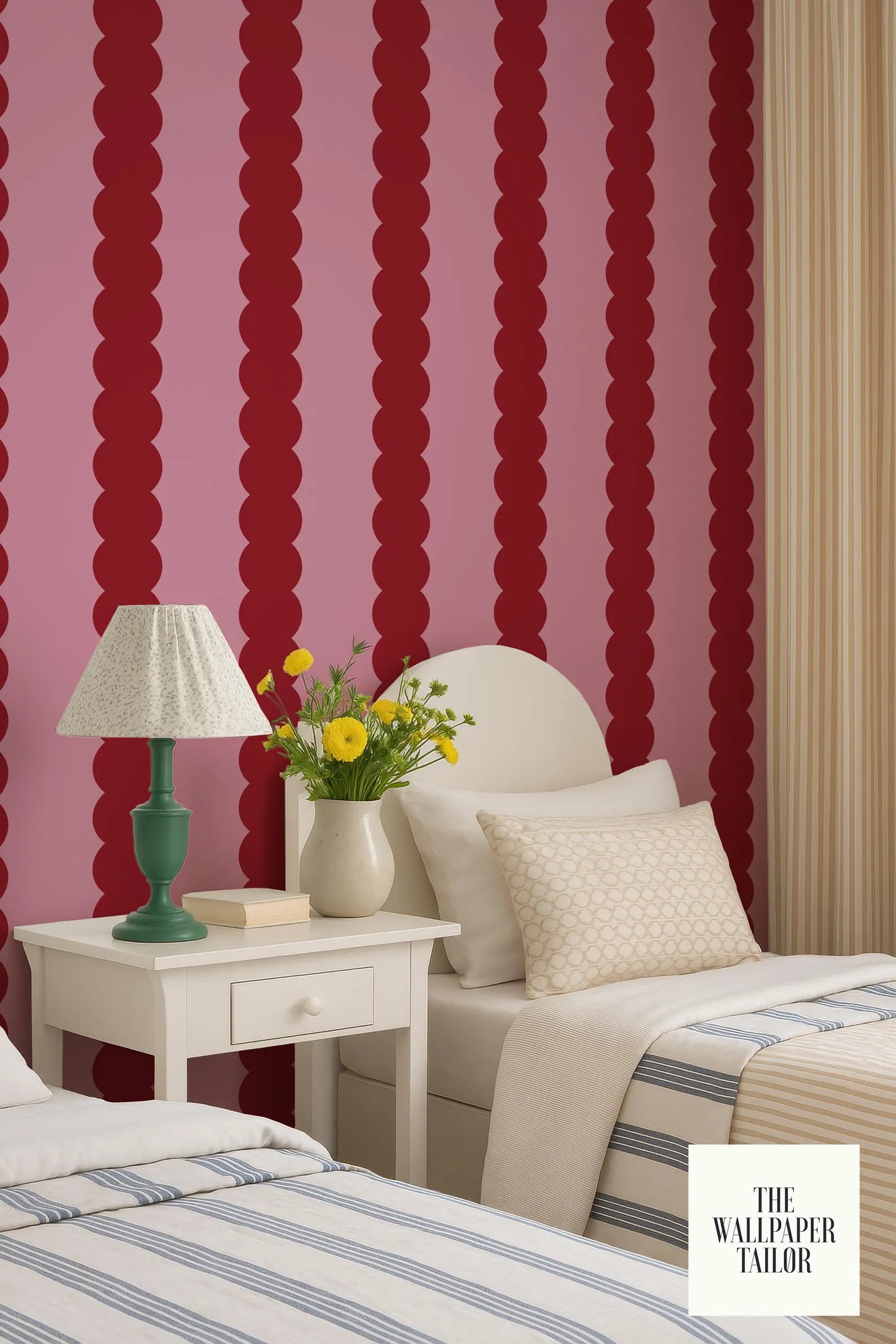 a bedroom with a red and white striped wallpaper, a white bed with a single pillow, and a white nightstand with a lamp and a vase of yellow flowers.
