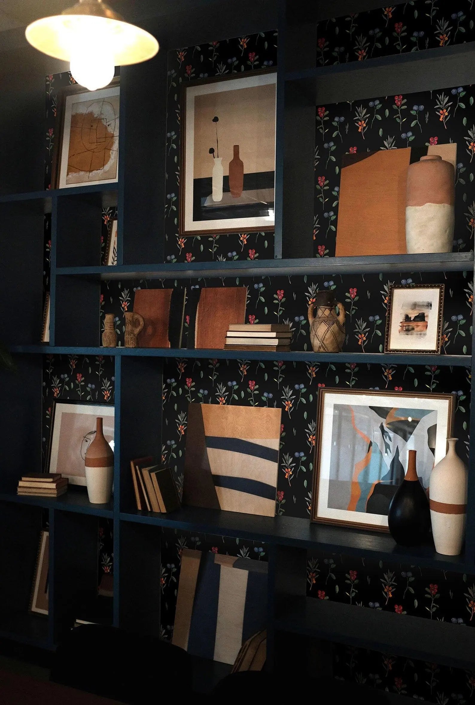 a dark blue bookshelf filled with various decorative items, including vases, books, and framed pictures. The bookshelf has a floral pattern on the wall behind it, adding a touch of elegance to the overall design.