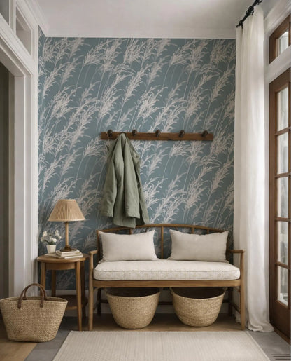 a cozy and inviting entryway with a bench, a coat rack, and a side table with a lamp. The wall behind the bench has a blue and white floral wallpaper, and there are two woven baskets placed on the floor next to the bench.