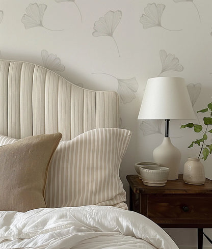 a bed with a white headboard sitting next to a lamp