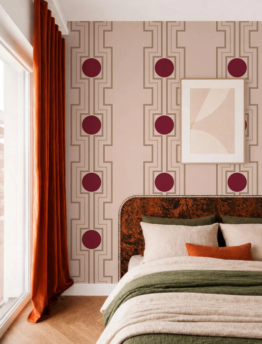 a bedroom with a large bed, a headboard with a floral pattern, and a window with orange curtains. The walls are decorated with a geometric pattern featuring circles and lines in shades of pink and beige.