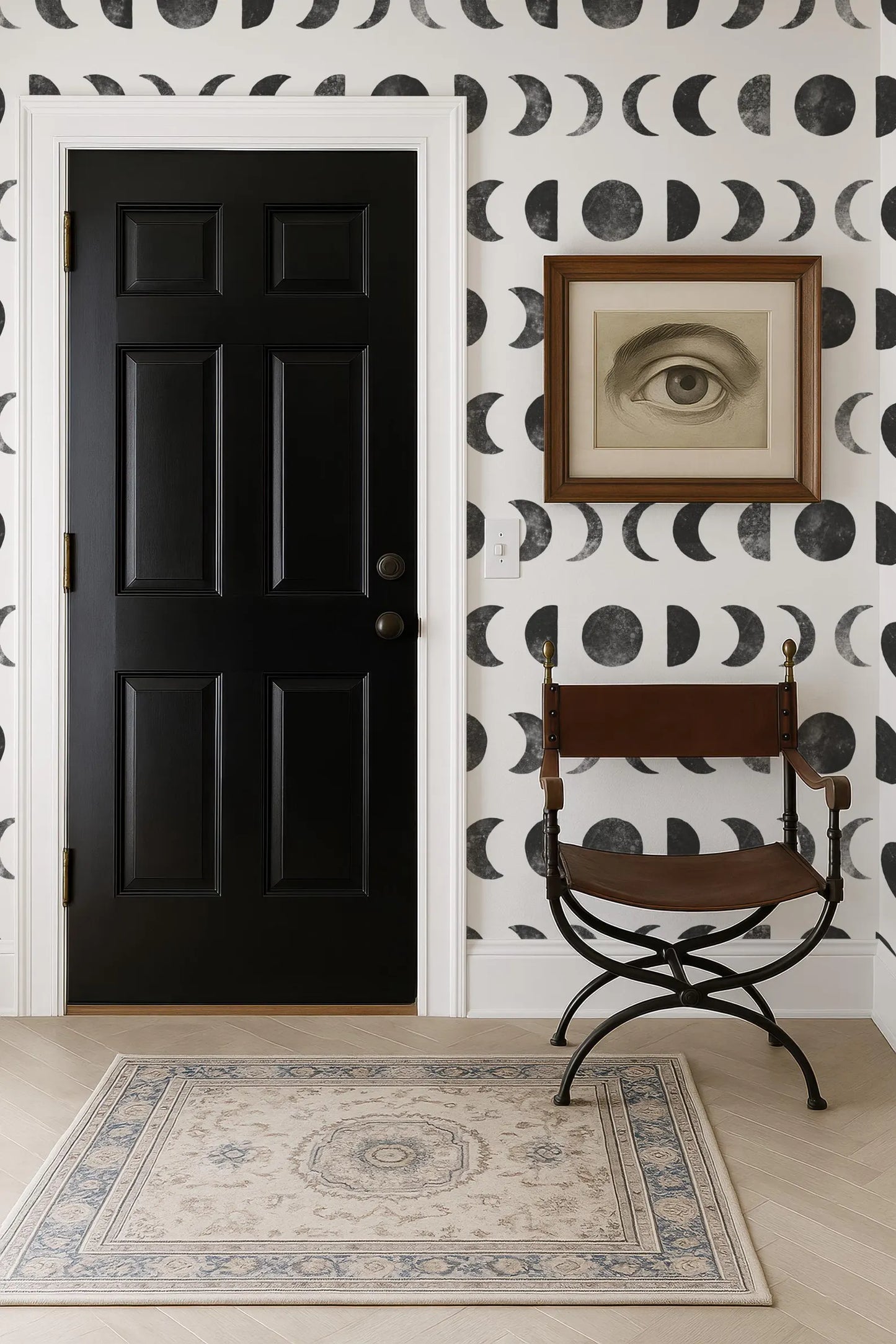 a black door, a brown chair, and a framed artwork on a wall with a black and white pattern.
