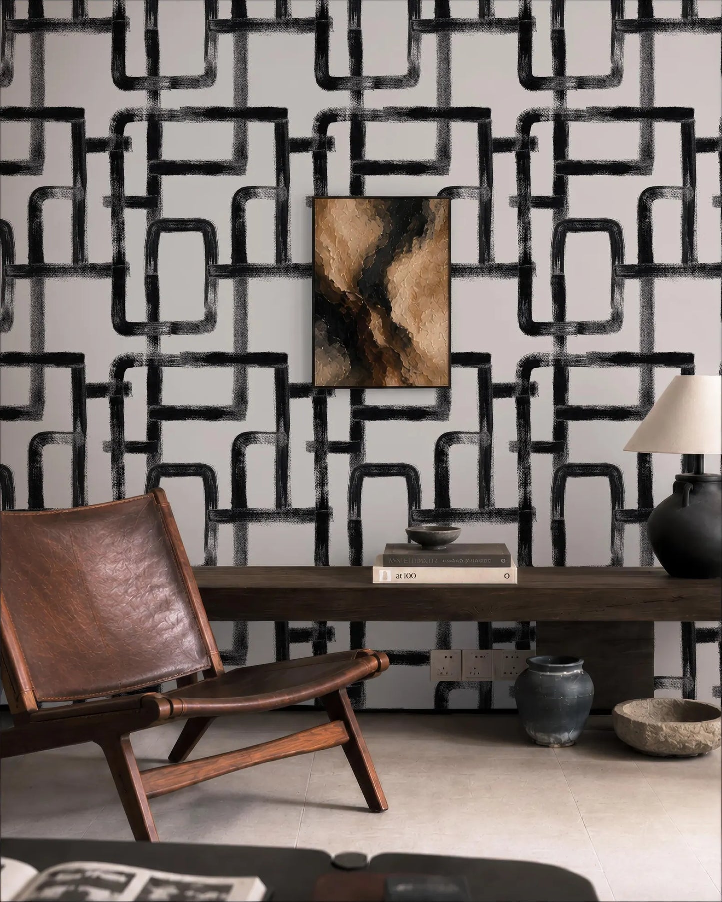 a modern living room with a leather chair, a wooden coffee table, and a black and white abstract wallpaper.