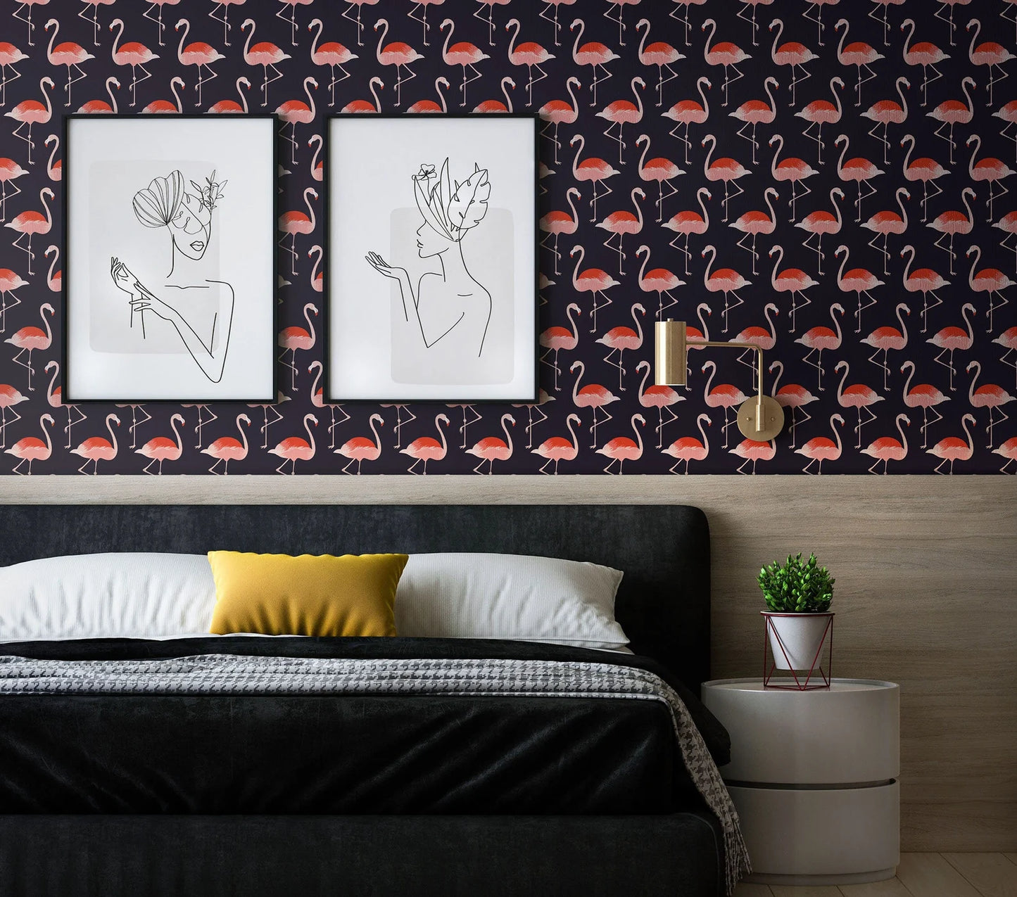 a bedroom with a black bed, a yellow pillow, and a white nightstand with a plant. Above the bed, there are two framed pictures of women with heads adorned with hats. The wall behind the bed has a repeating pattern of pink flamingos.