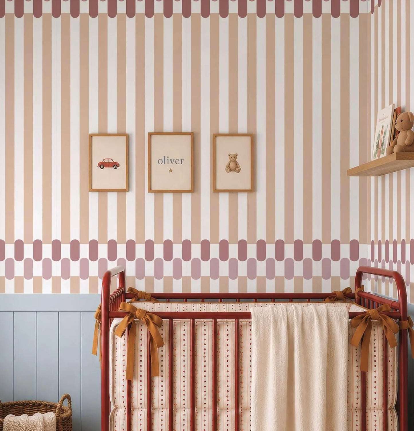 a nursery room with a red metal crib, a wooden shelf with a stuffed animal, and three framed pictures on the wall.
