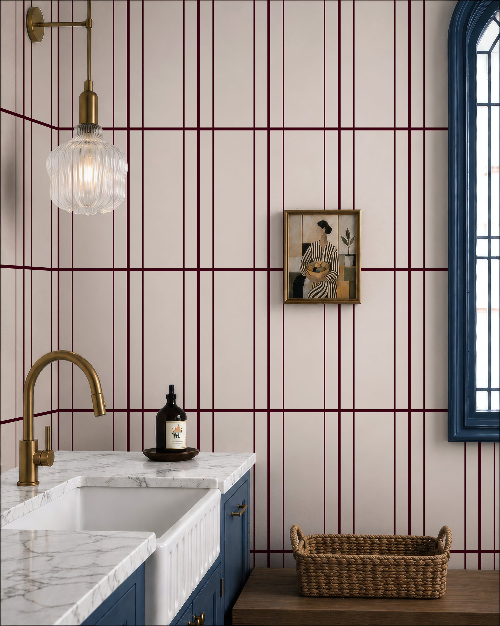 a modern bathroom with a white and burgundy striped wall, a marble countertop, a gold faucet, and a framed artwork on the wall.