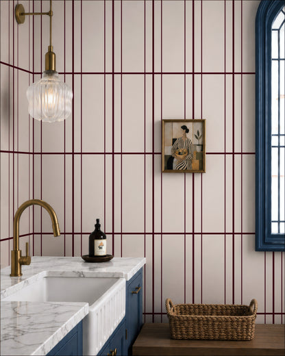 a modern bathroom with a white and burgundy striped wall, a marble countertop, a gold faucet, and a framed artwork on the wall.