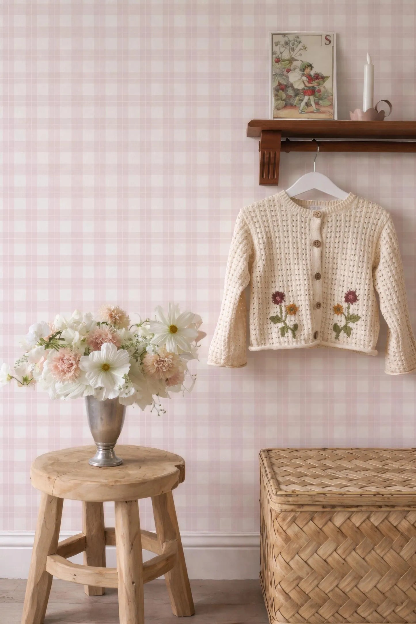 a cozy and charming interior scene with a wooden stool, a vase of flowers, a wooden shelf, and a knitted cardigan.